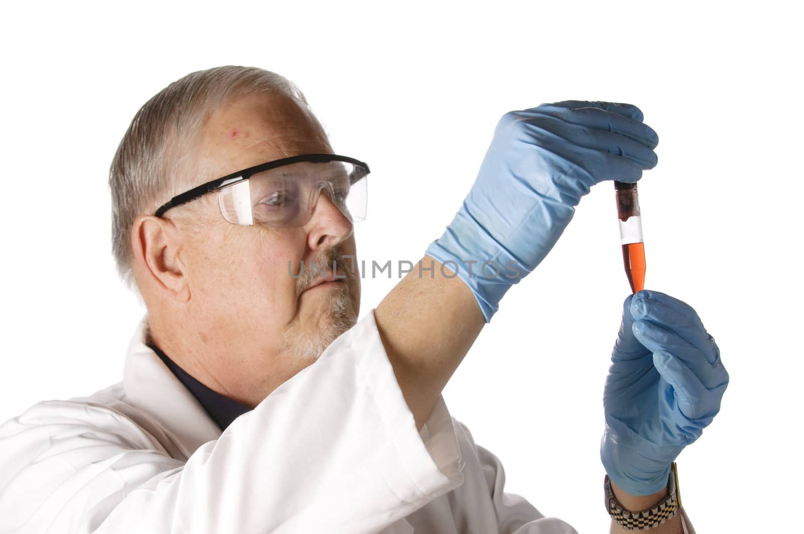 Dramatic lighting of an older doctor looking at a plasma vial for analysis