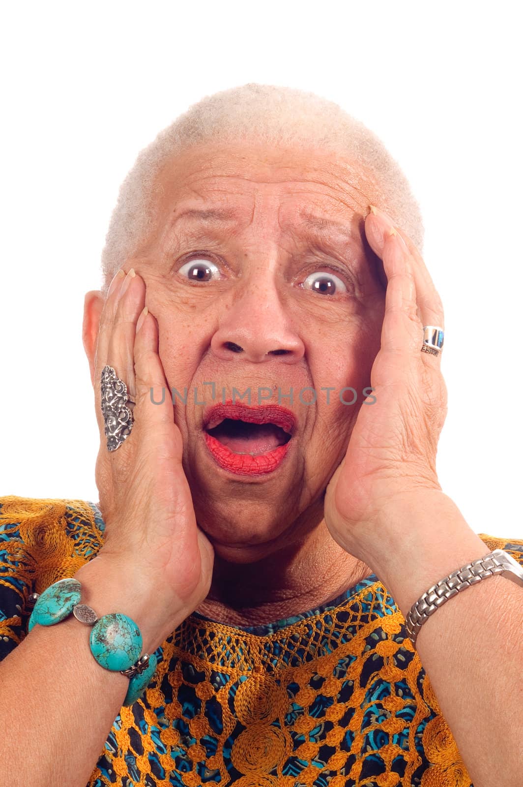 Elderly African American woman in anguish looking shocked, clasping head