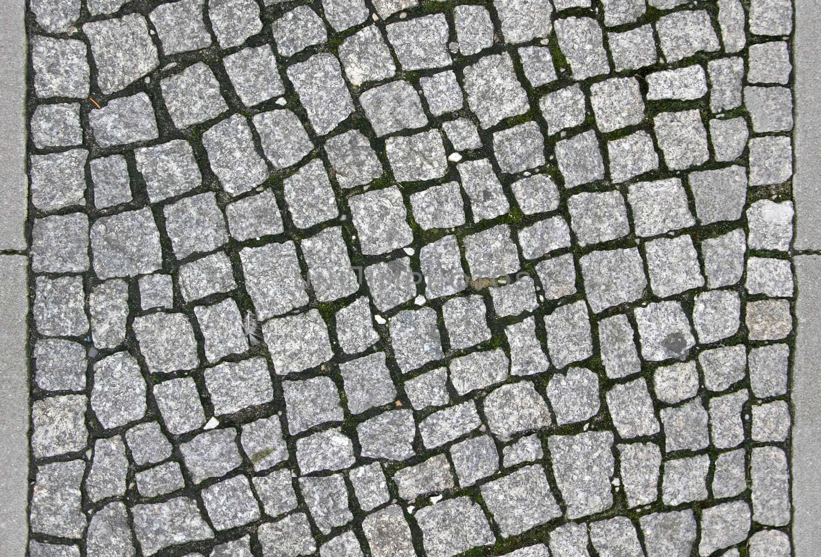 small cobblestone sidewalk made of cubic stones - tileable texture