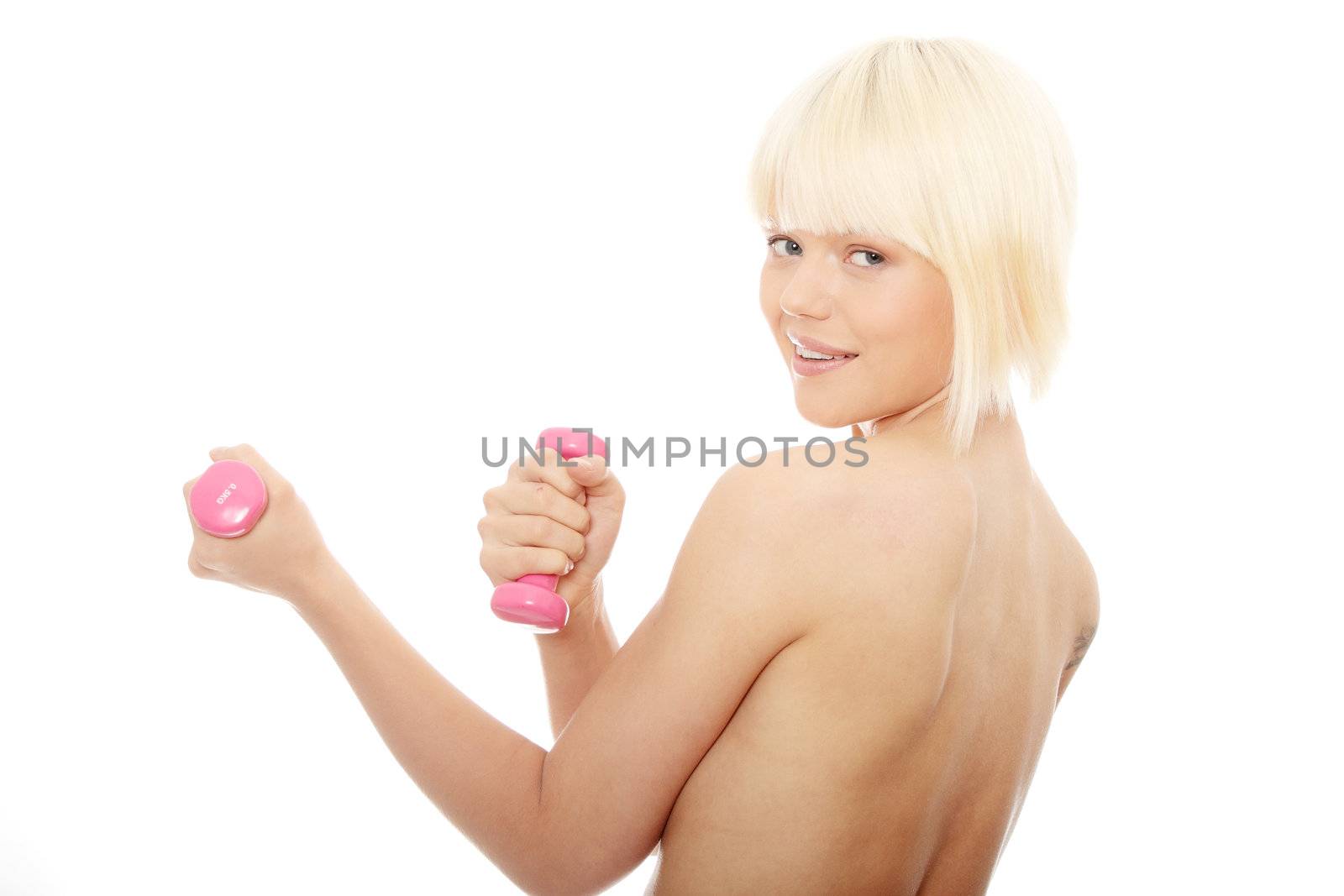 Young topless woman exercising with dumb bells