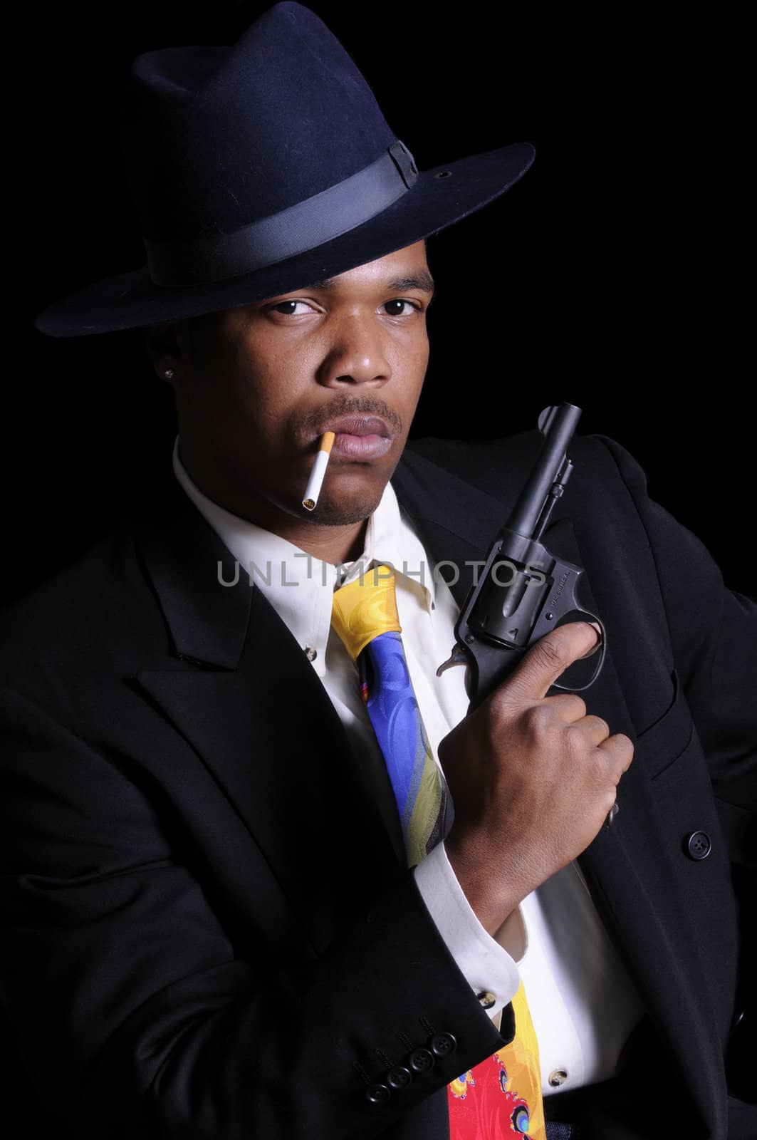 young African American man in a hat and suit with 38 revolver