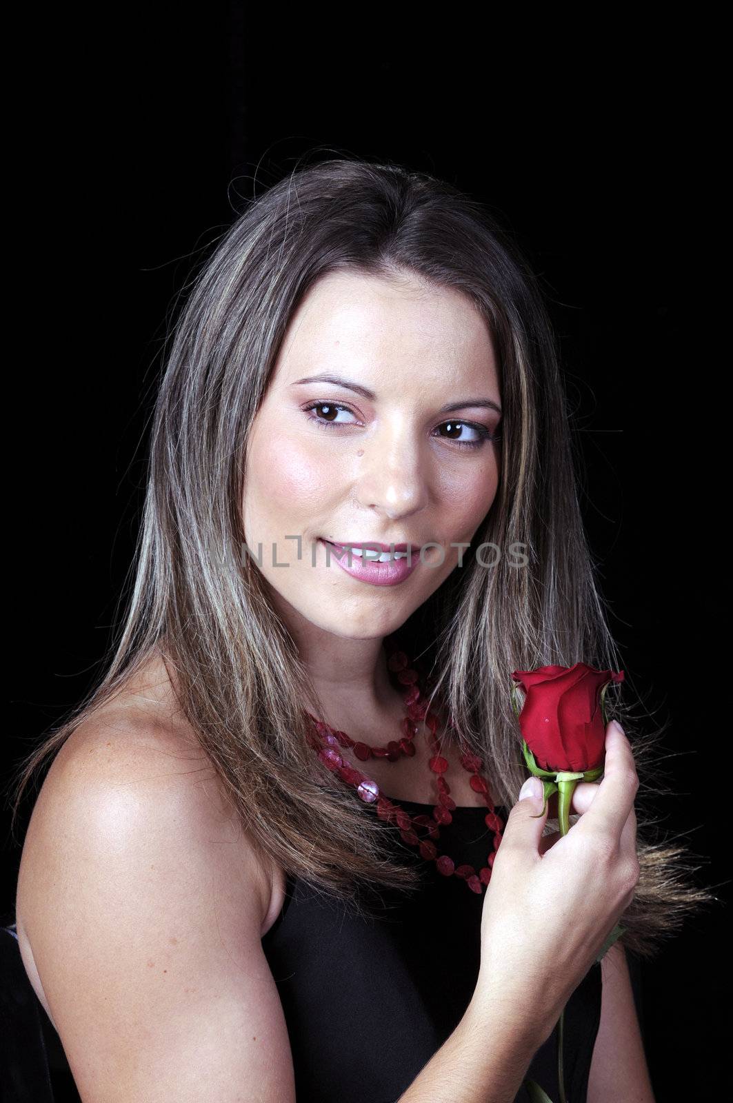 Beautiful young brunette woman holding a red rose for valentines
