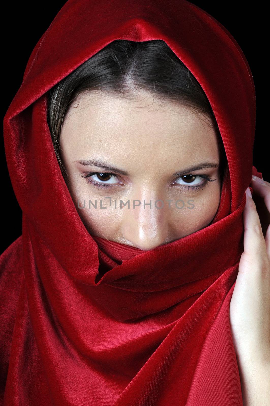 Beautiful young brunette woman in closeup with red shawl over face