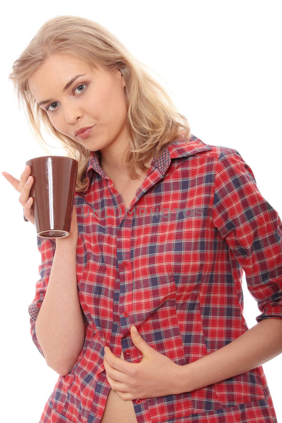 The beautiful young woman drinks morning coffee or tea
