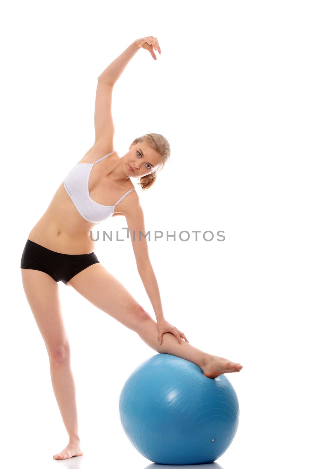 Young woman exercising with fitness ball. Isolated on white