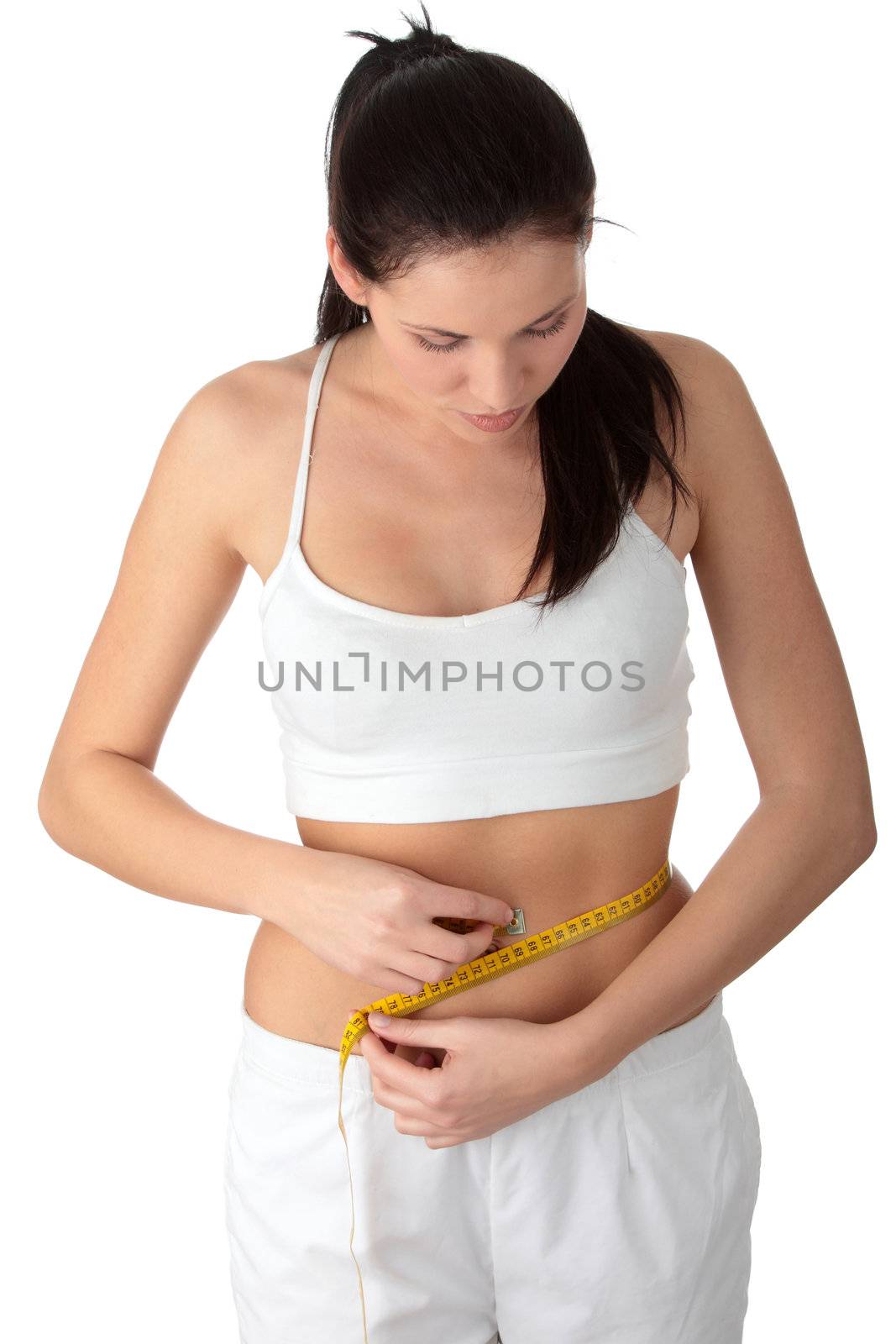 Sexy, fit, young woman measuring her waist, over white background
