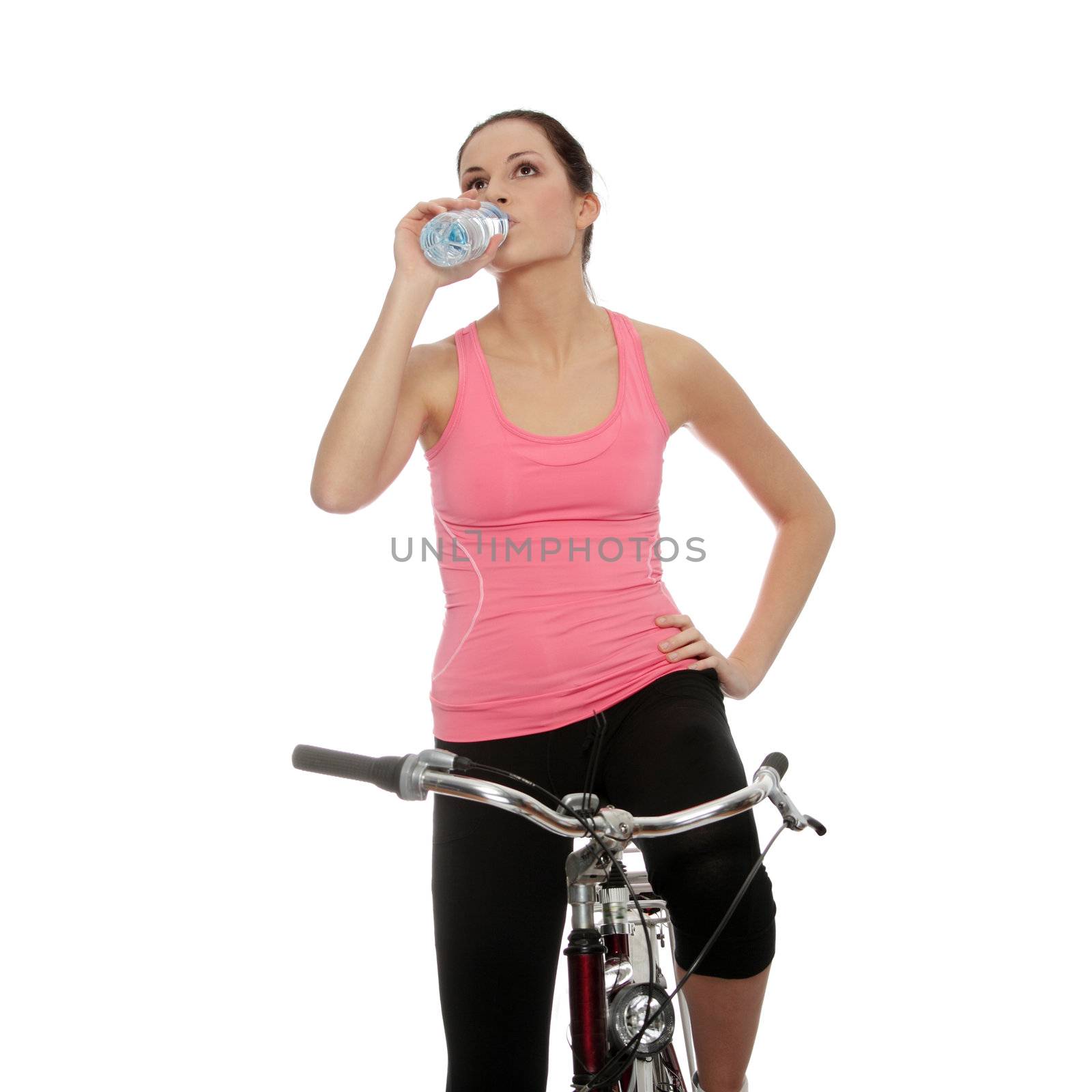 Attractive brunette woman with bike drinking water. over white background