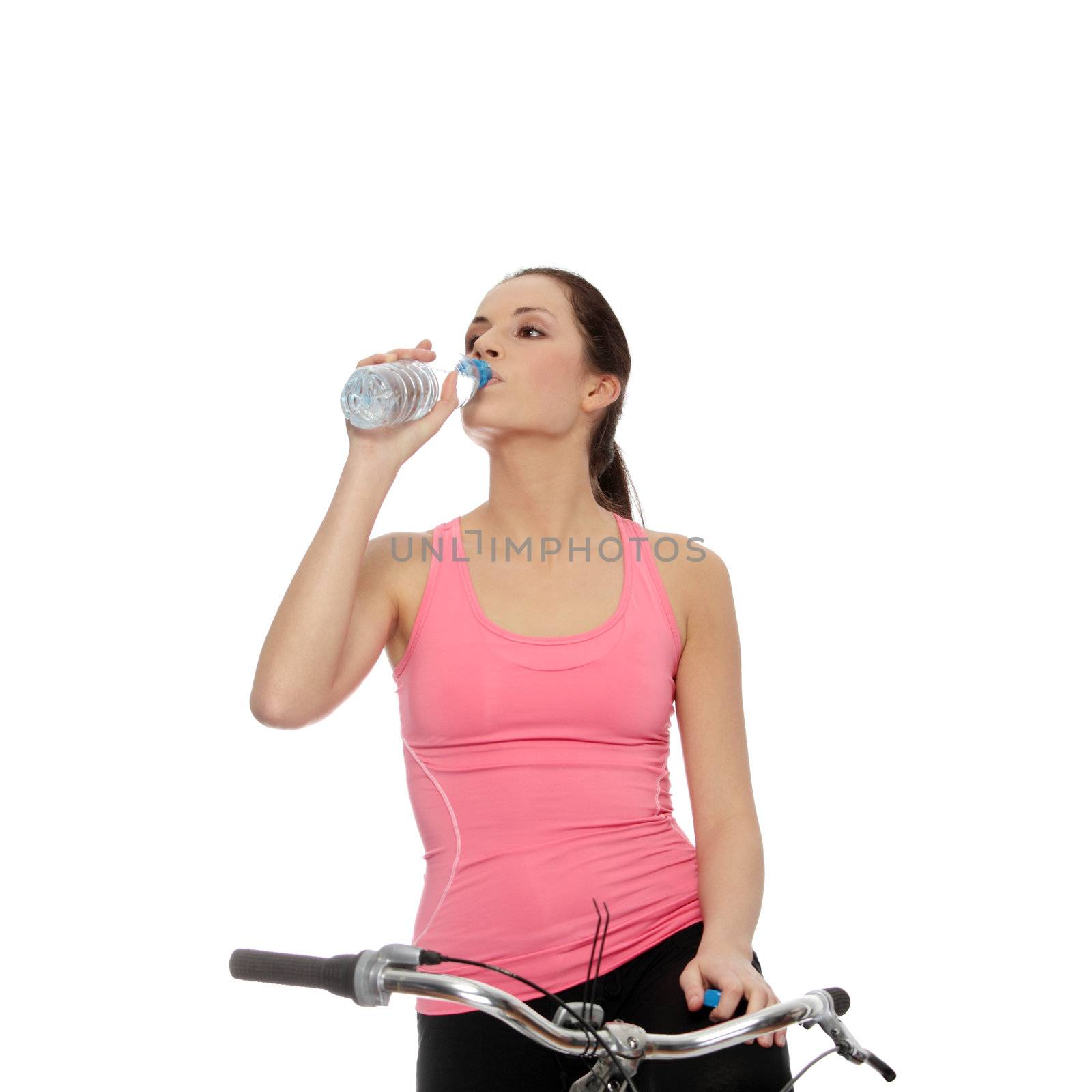 Attractive brunette woman with bike drinking water. over white background