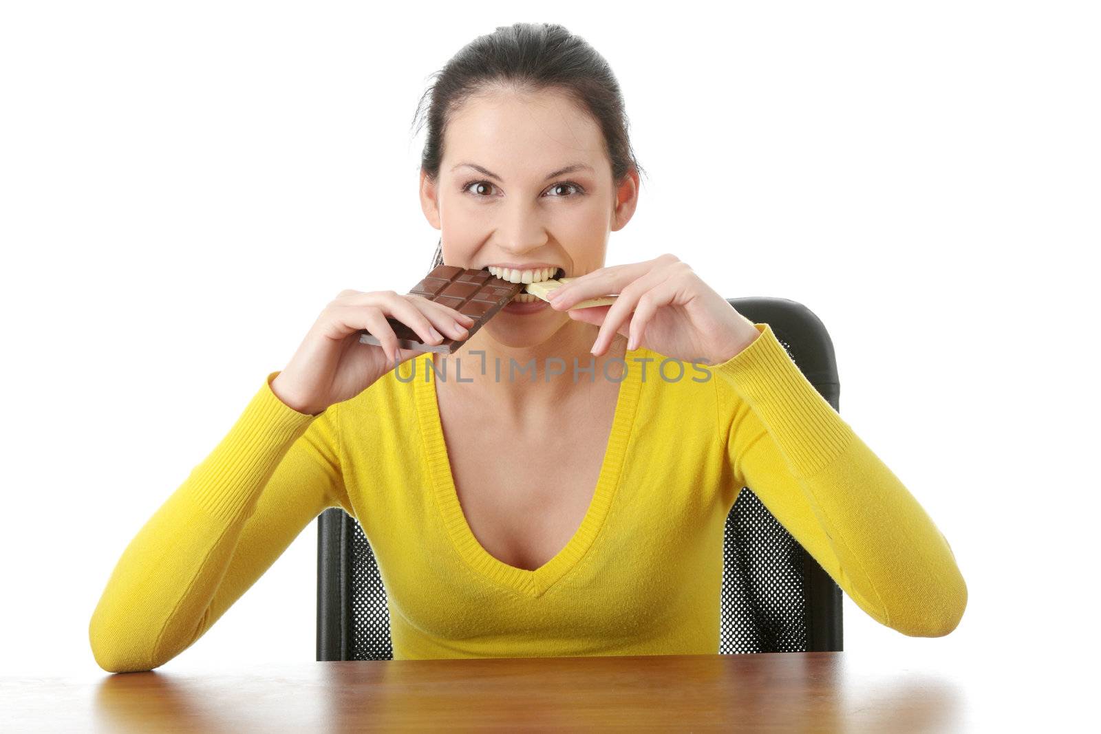 Portrait of young happy smiling woman eating dark and white chocolate