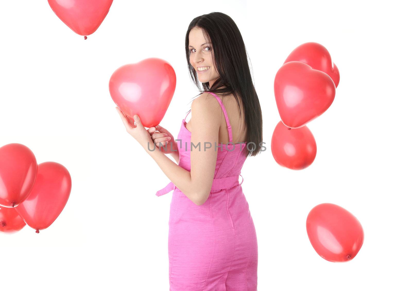 Beautiful young woman in pink elegant dress with red heart shaped balloon on a white background (love and valentines concept)