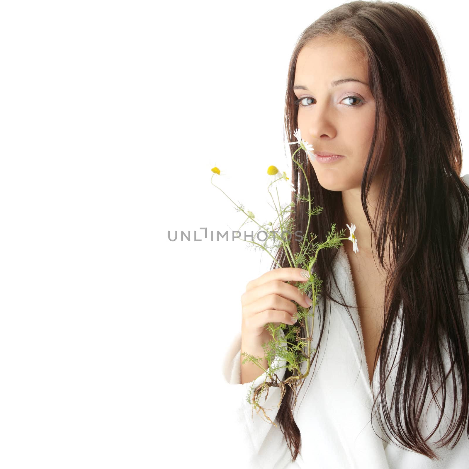 Beautiful young caucasian woman in bathrobe smeling daisy calm portrait. Isolated
