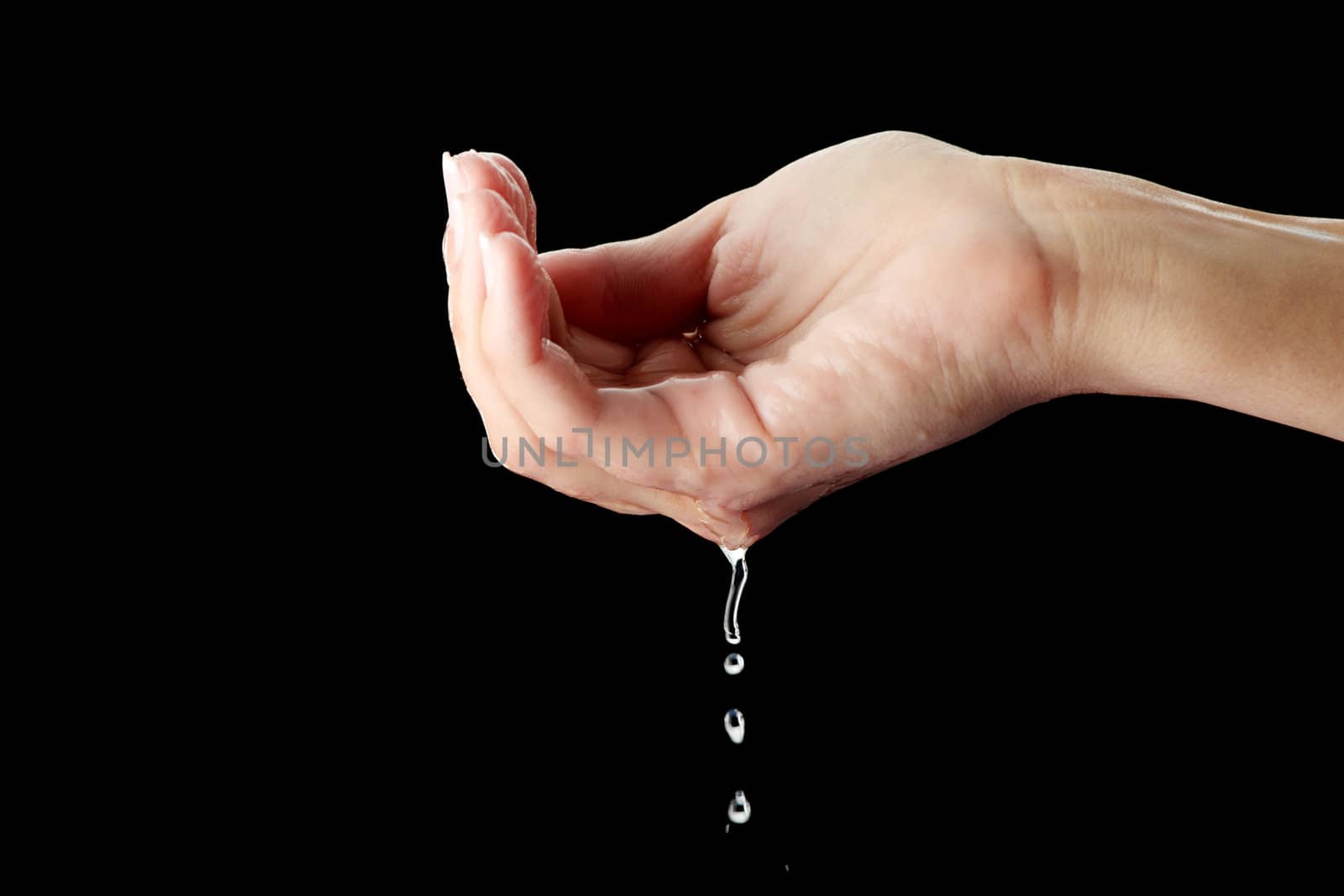 Beautiful female hands with water isolated on black background