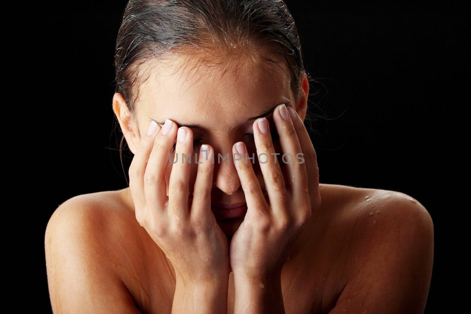 Wet teen woman isolated on black background