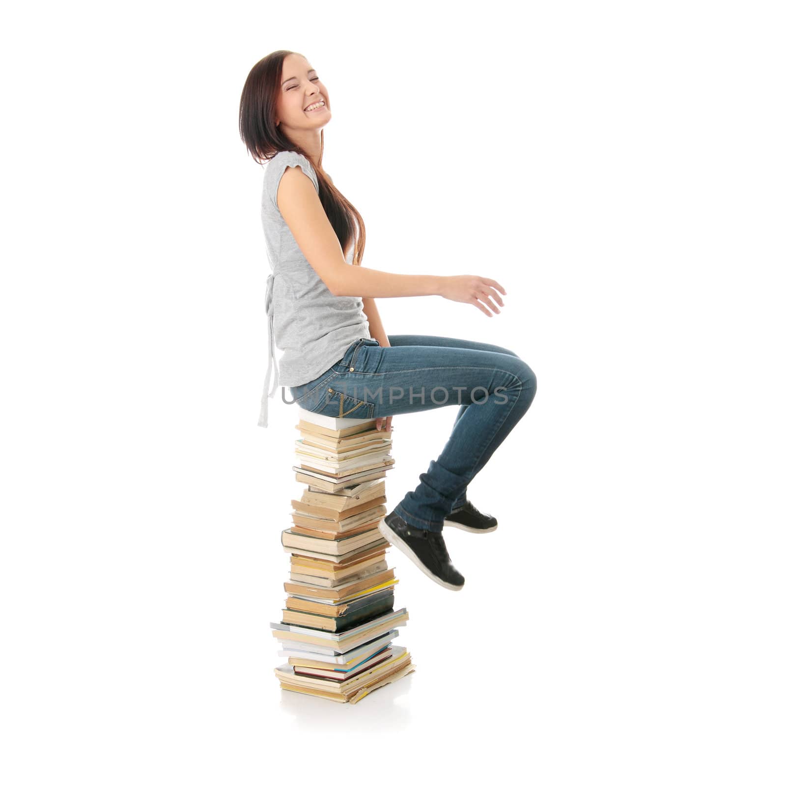 Young teen woman sitting on books isolated on white background