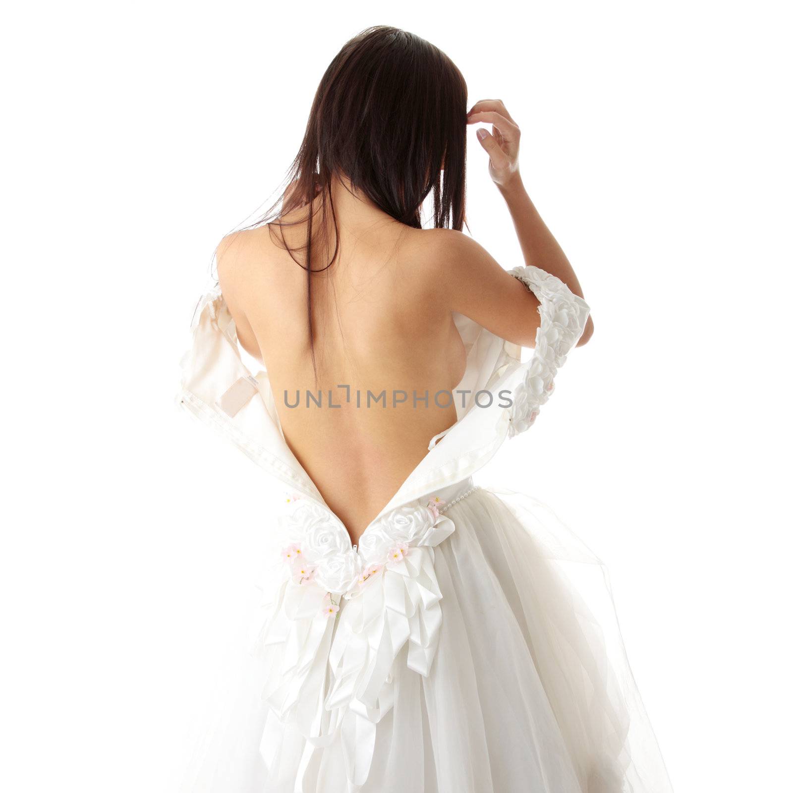 Bride dressing up her wedding dress on nude body, isolated