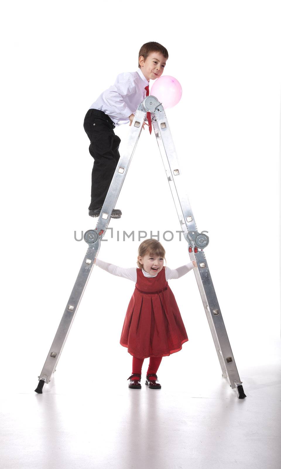 Preschoolers playng with ladder - studio shot over white