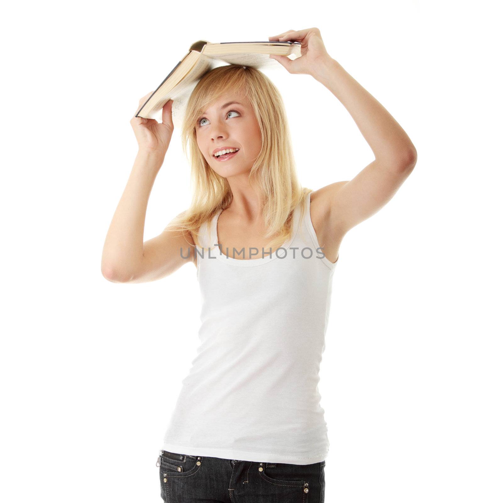 Teen girl with book over her head, isolated on white