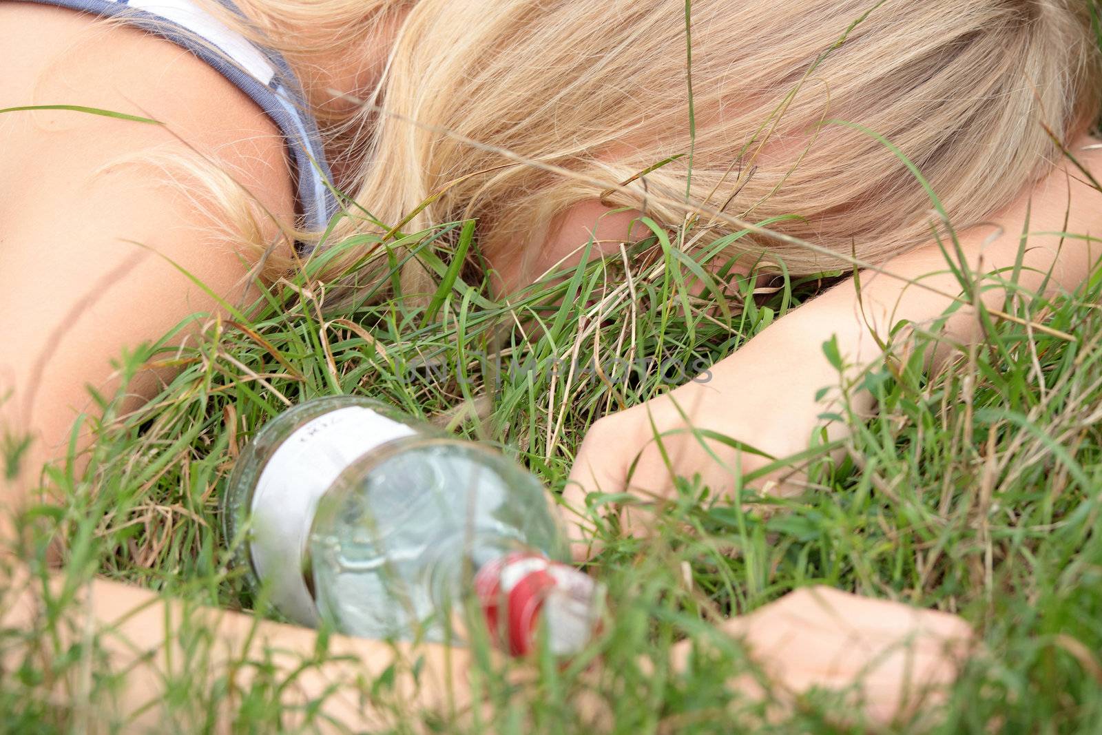 Teen alcohol addiction (drunk teen with vodka bottle)