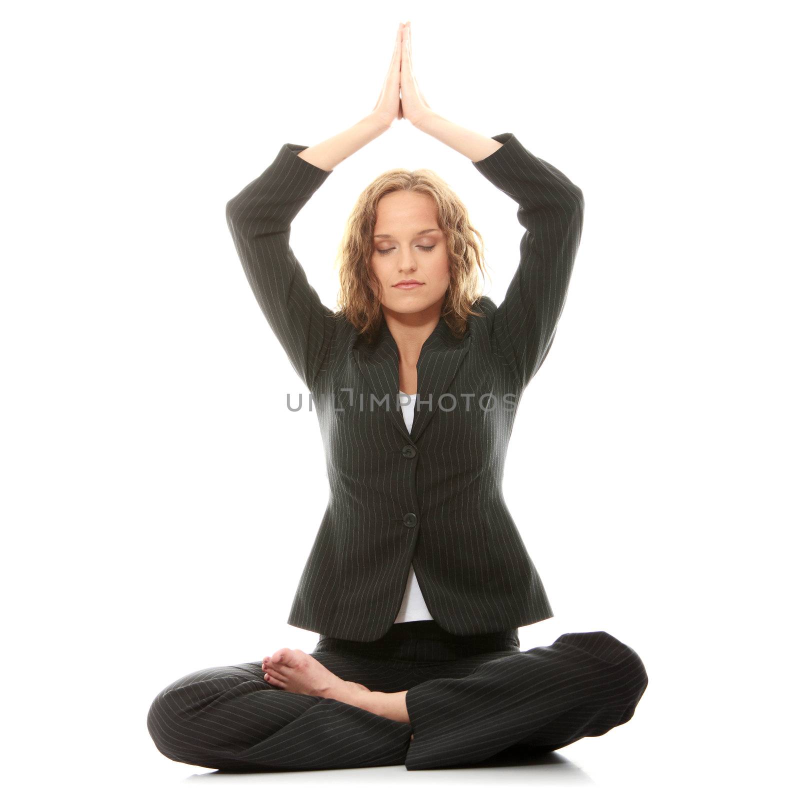Beautiful businesswoman sitting on white desk in lotus flower position of yoga. Isolated on white