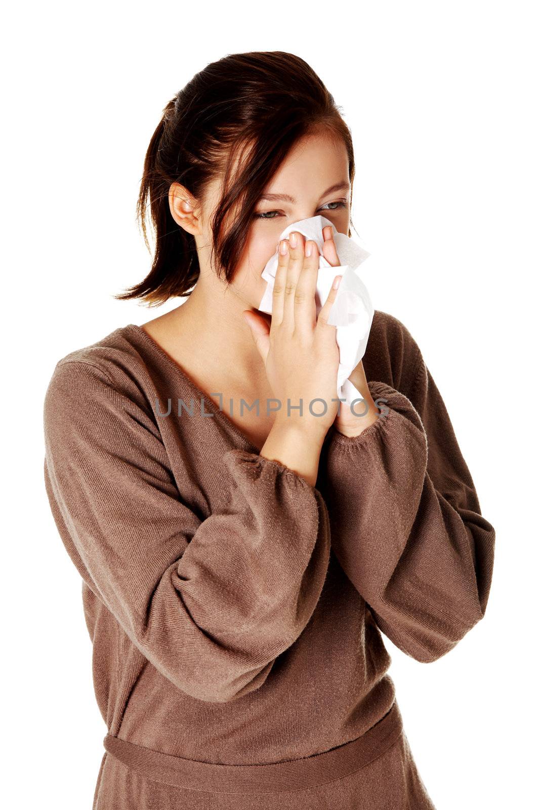 Young pretty caucasian girl blowing her nose. Isoalted on white.