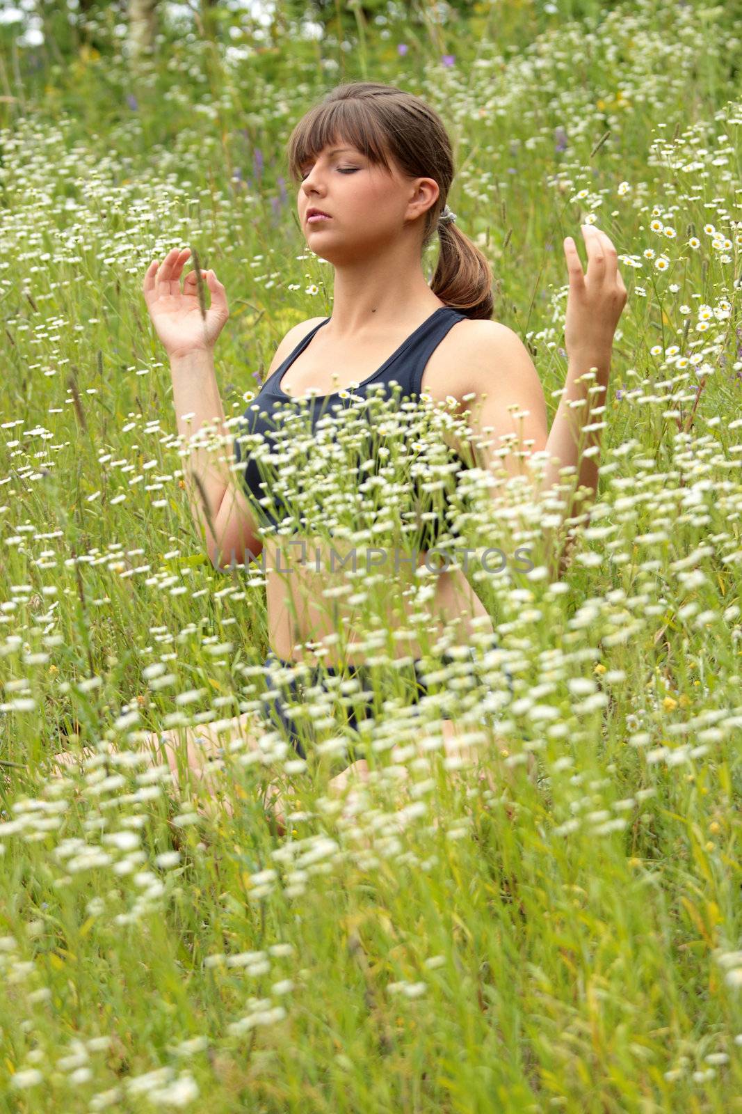 A young woman doing yoga outside in natural environment