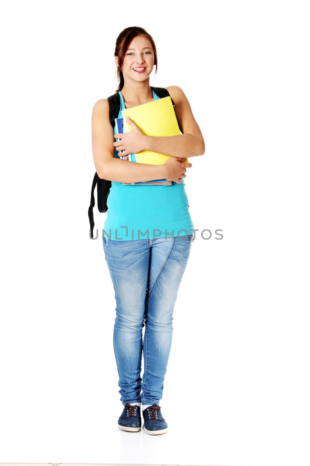Smiling teenage girl with backpack holding notes . by BDS