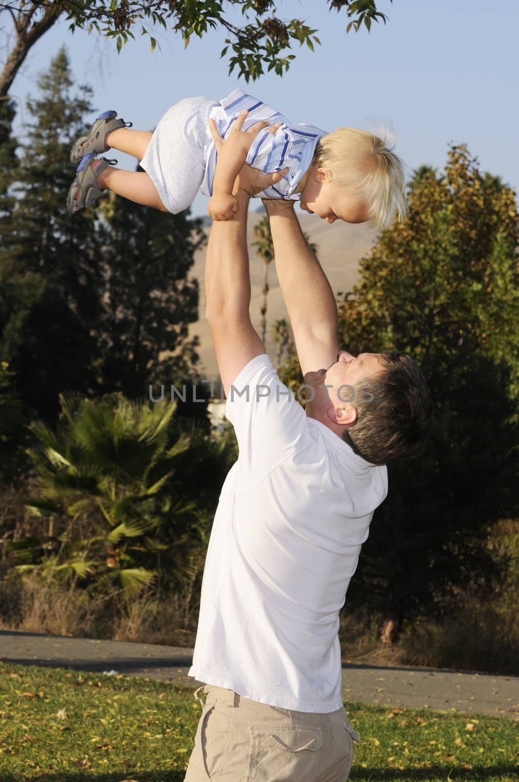 Infant being lifted into the air by father