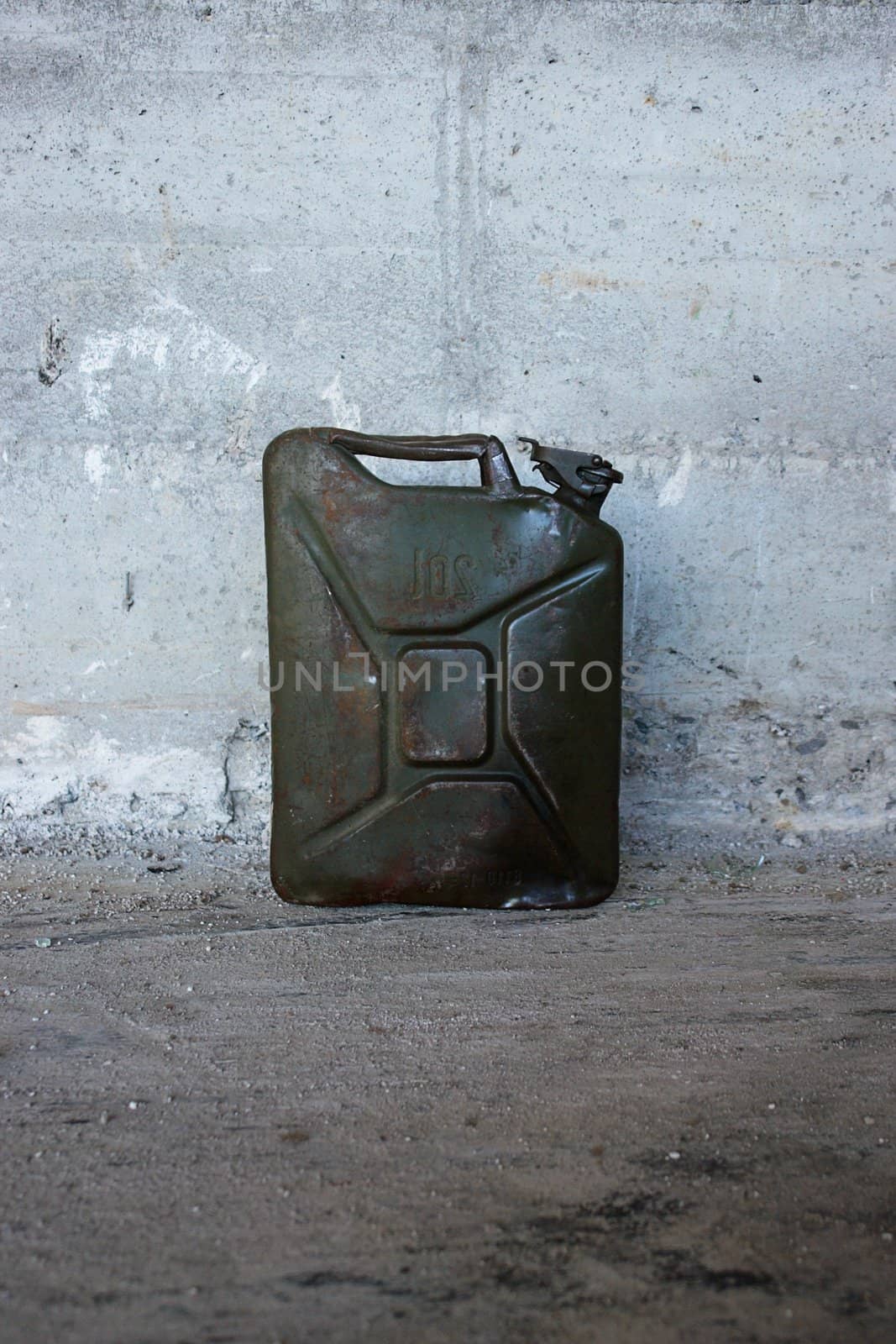 a green jerry can on concrete floer.