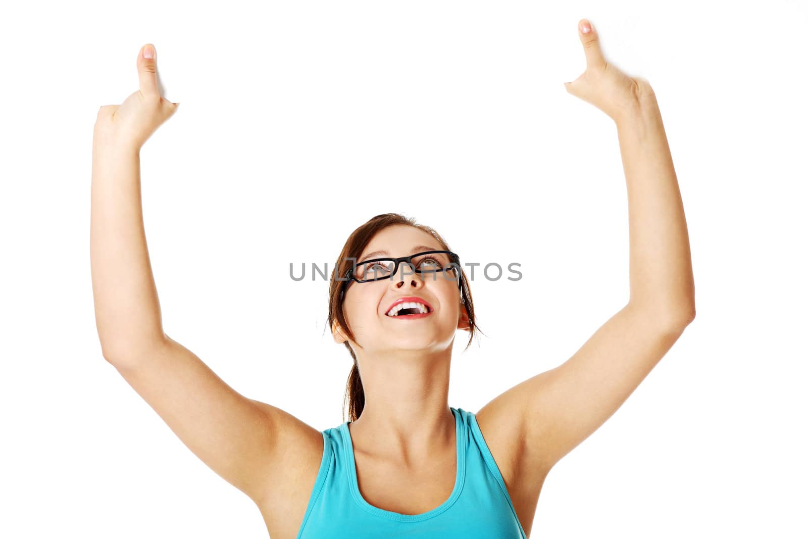 Young girl in glasses holding sheet of paper in the air and smiling over white.