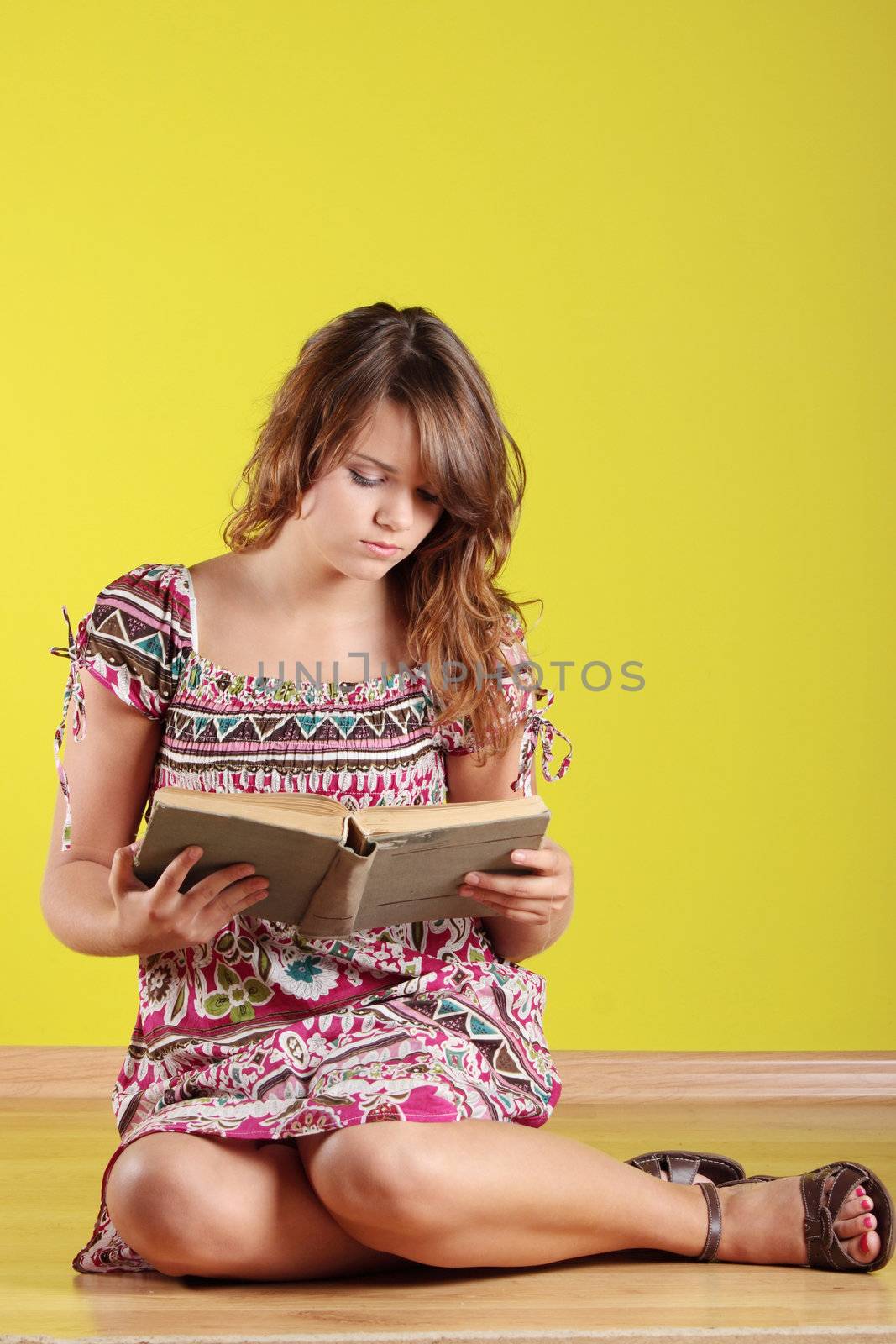 Teen woman sitting on the flor and reading a book
