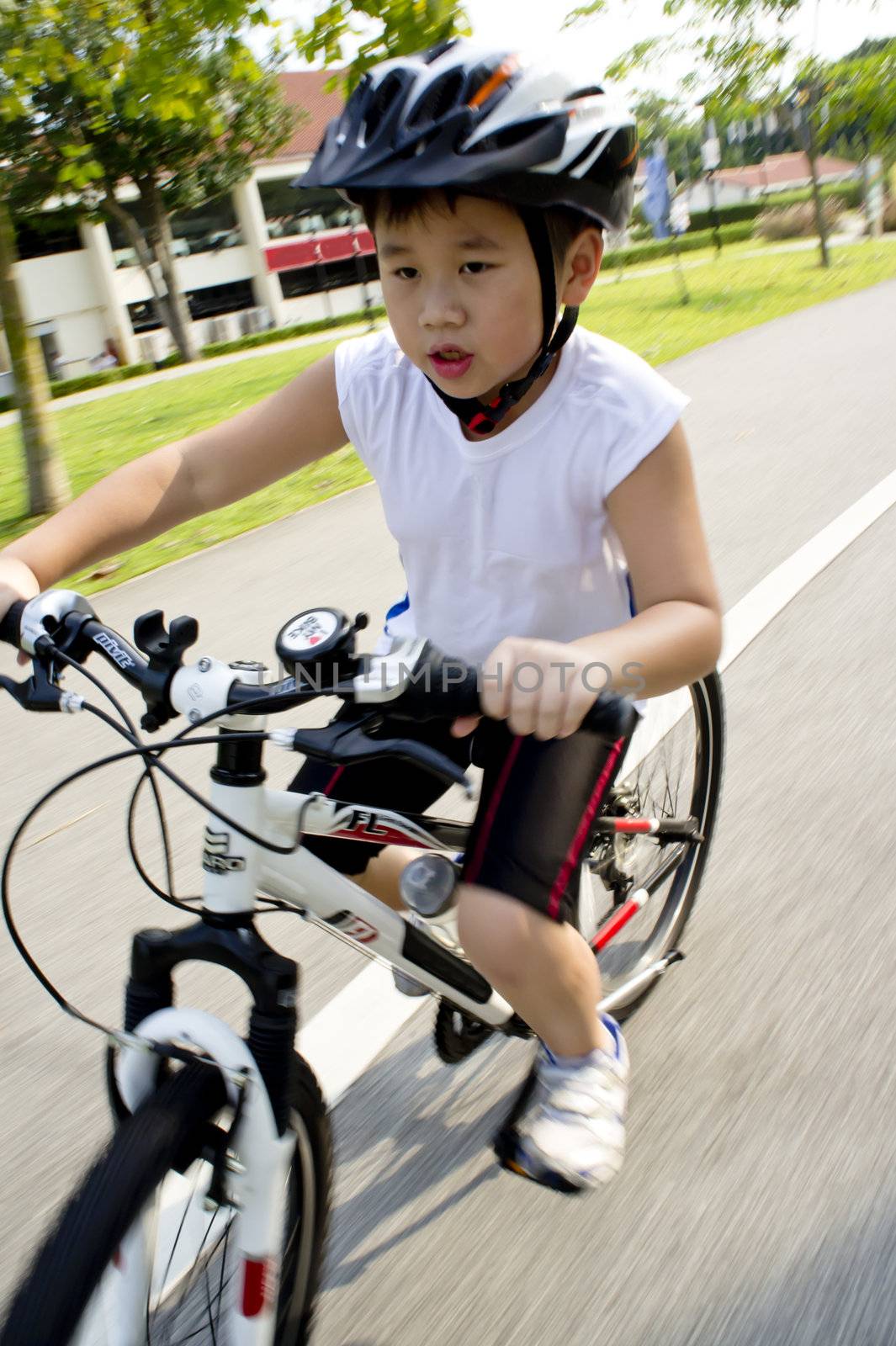 Cycling boy with white bicycle dashing forward 