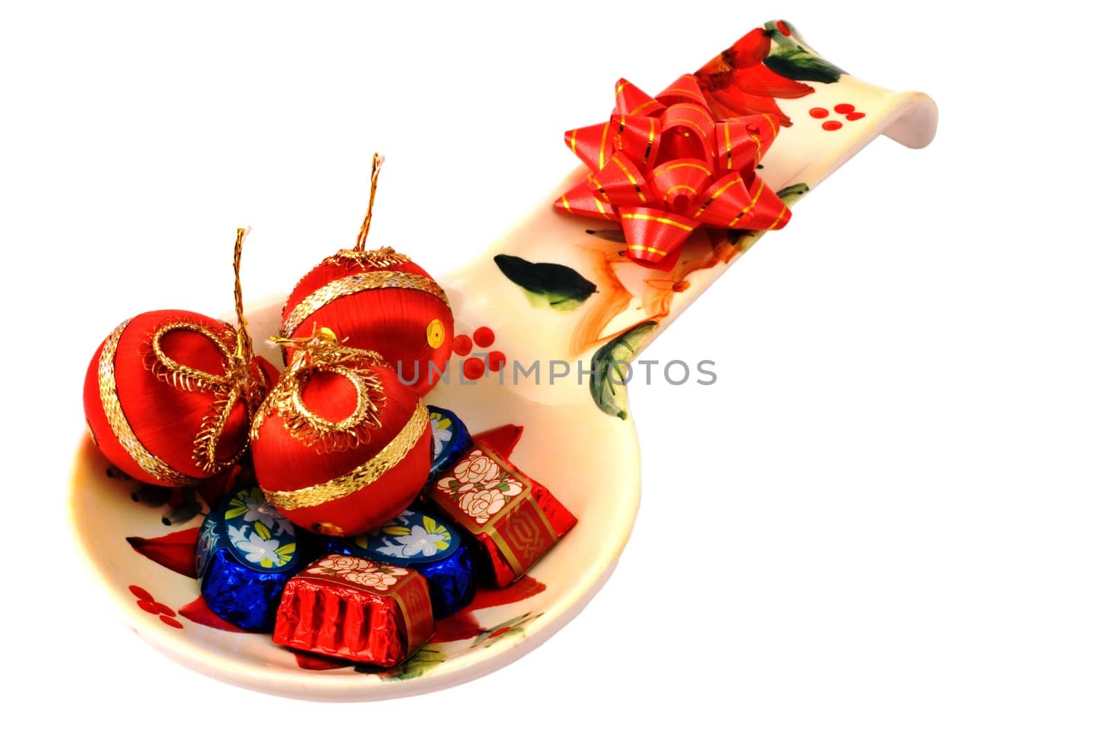 Chocolates and Christmas ornaments in a plate isolated on white