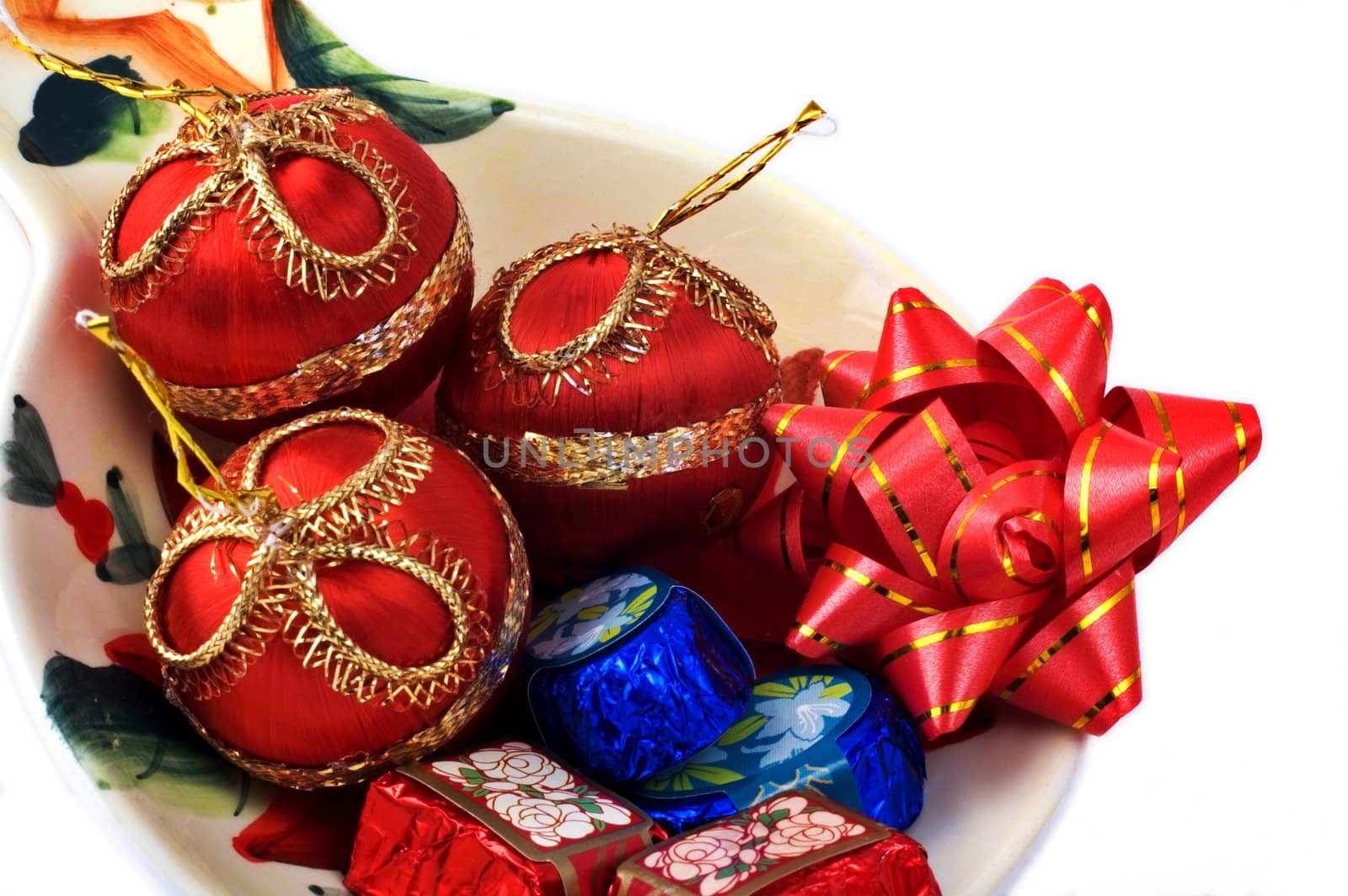 Chocolates and Christmas ornaments in a plate isolated on white