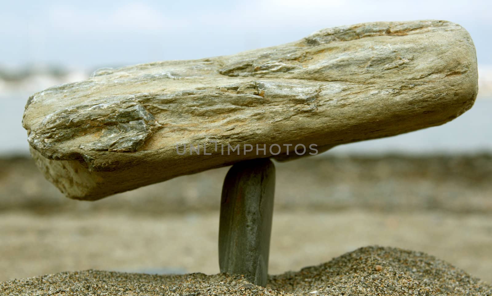 two stones in equilibrium, sand beach background