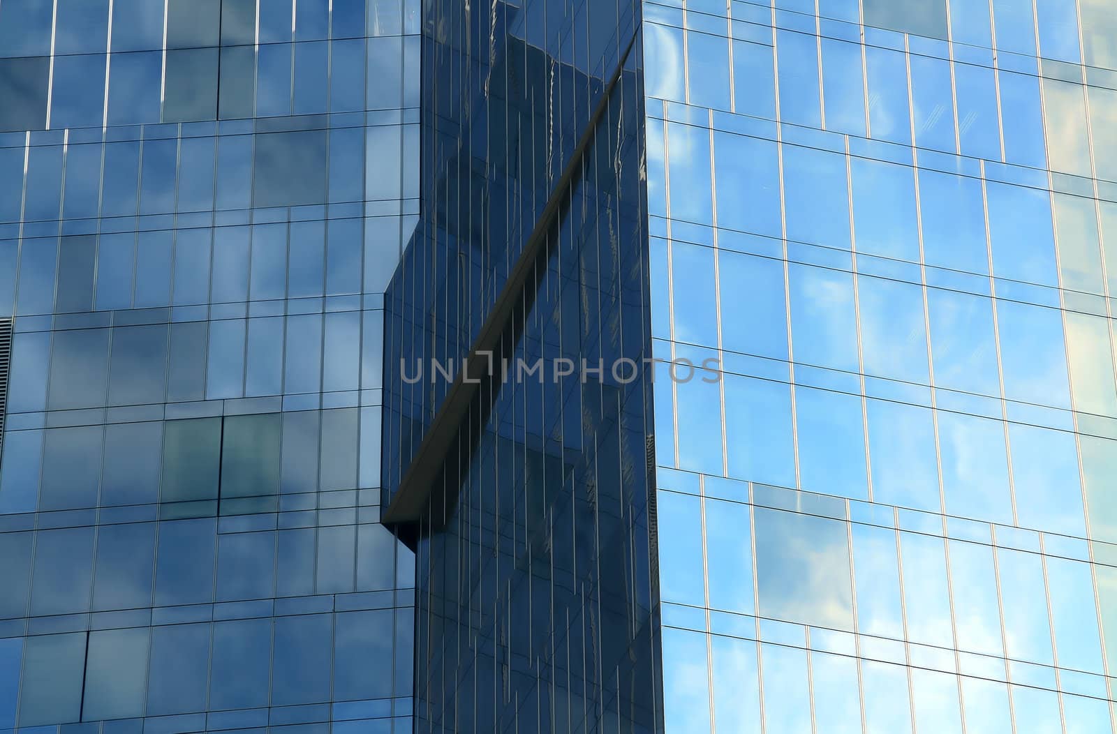 Business building, blue glass, clouded sky reflections
