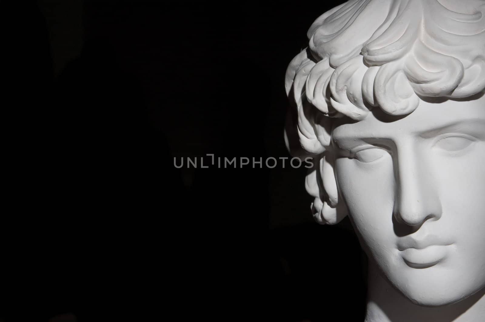 Plaster head of sculpture, black background