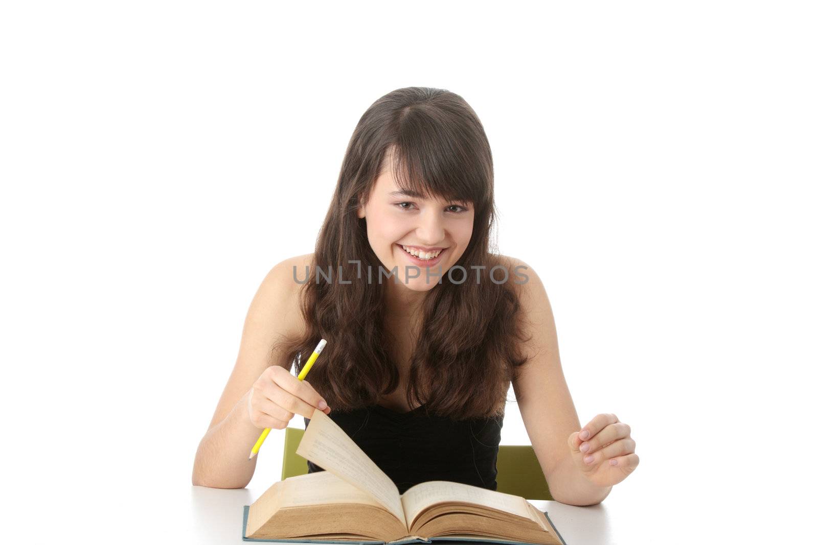 Teen girl learning at the desk , isolated on white