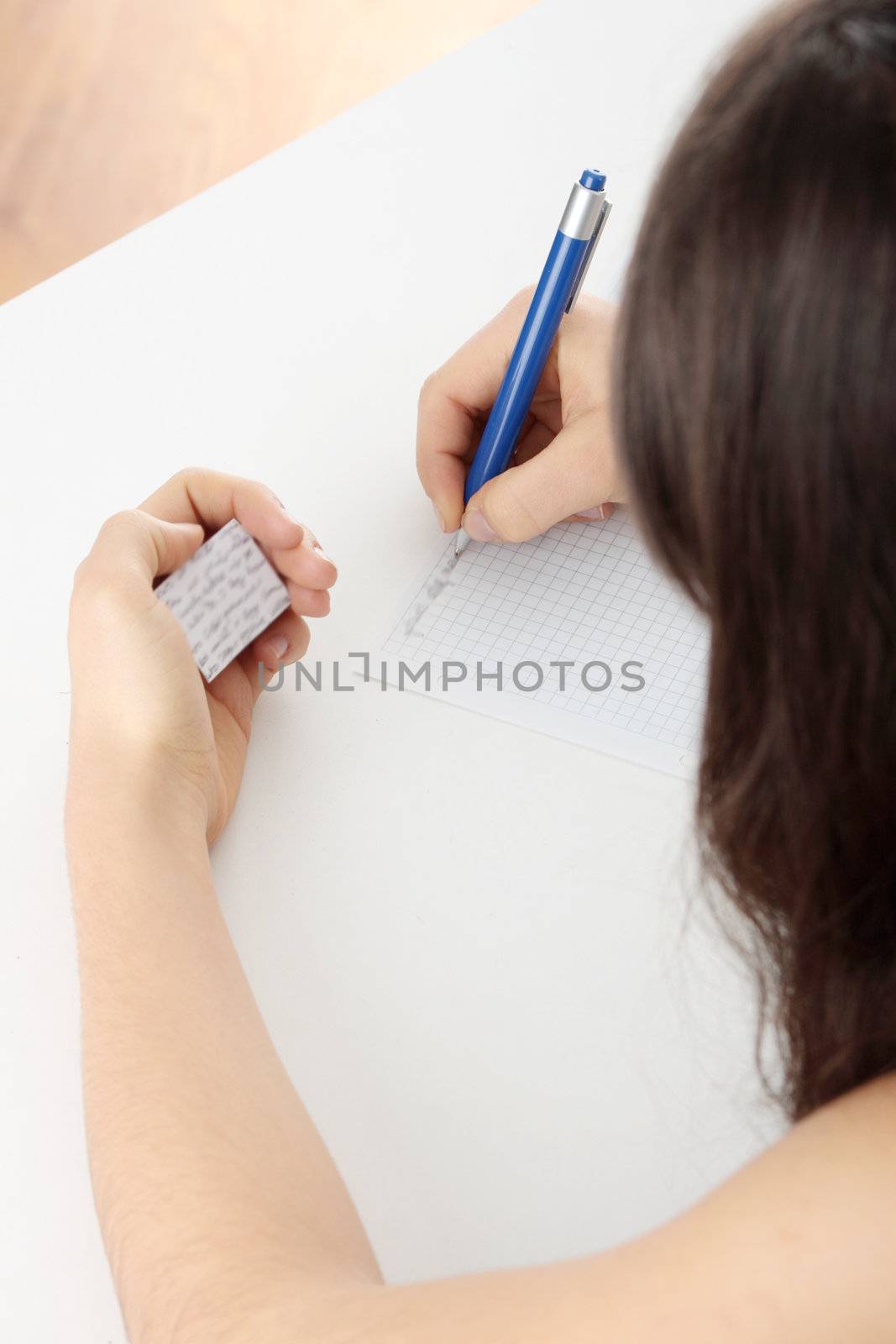 Young caucasian female student stands by school desk and cheat
