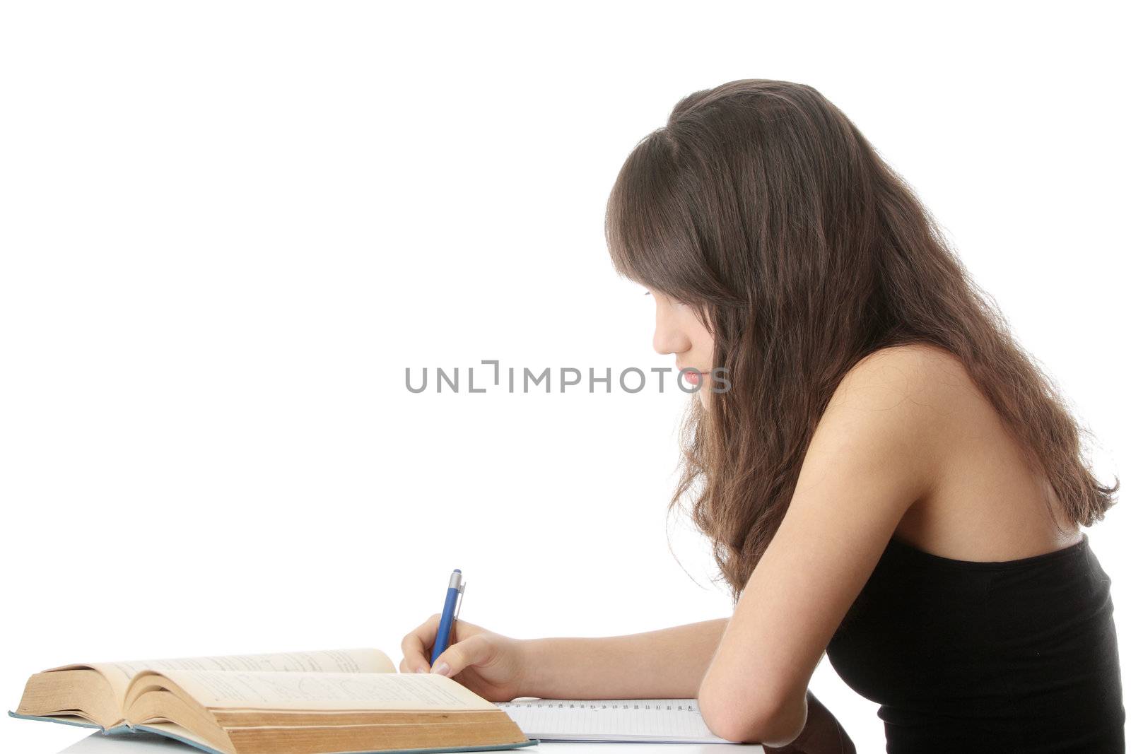 Teen girl learning at the desk, isolated on white