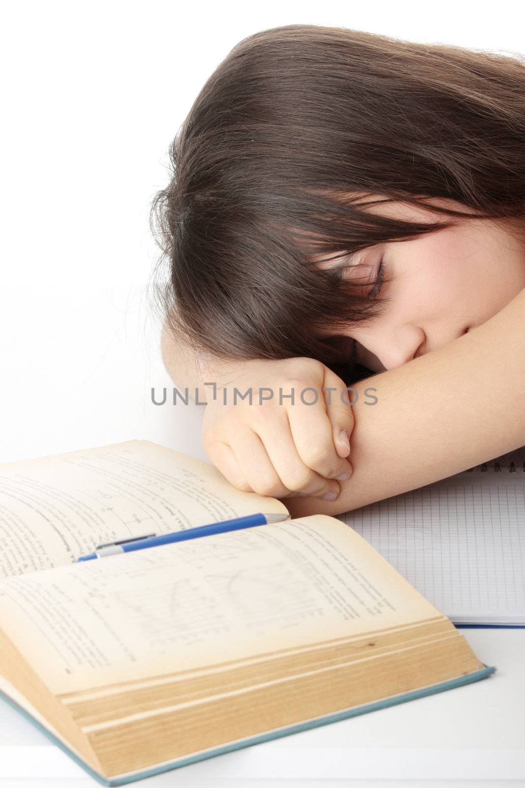 Sleeping while learning - tired teen woman sleeping on desk, over white background