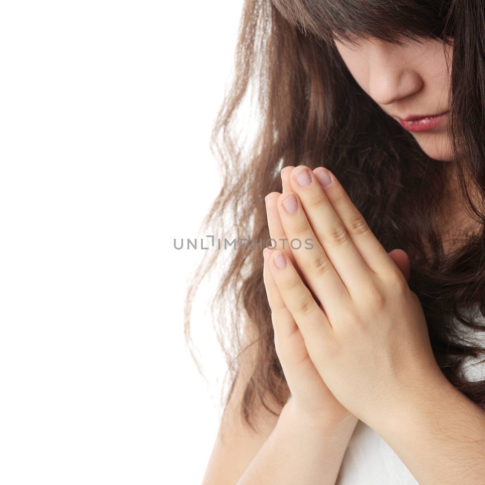 Closeup portrait of a young caucasian woman praying isolated on white background