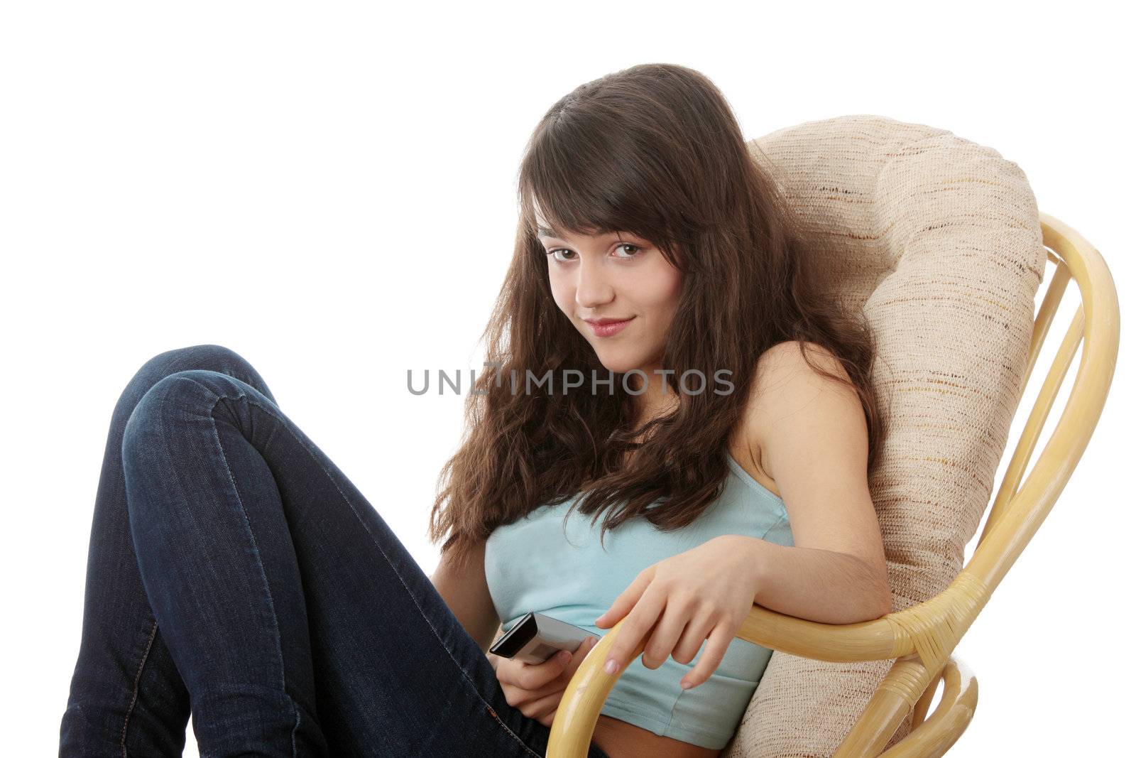 Teen woman watching TV with remote control while sitting on armchair view from TV