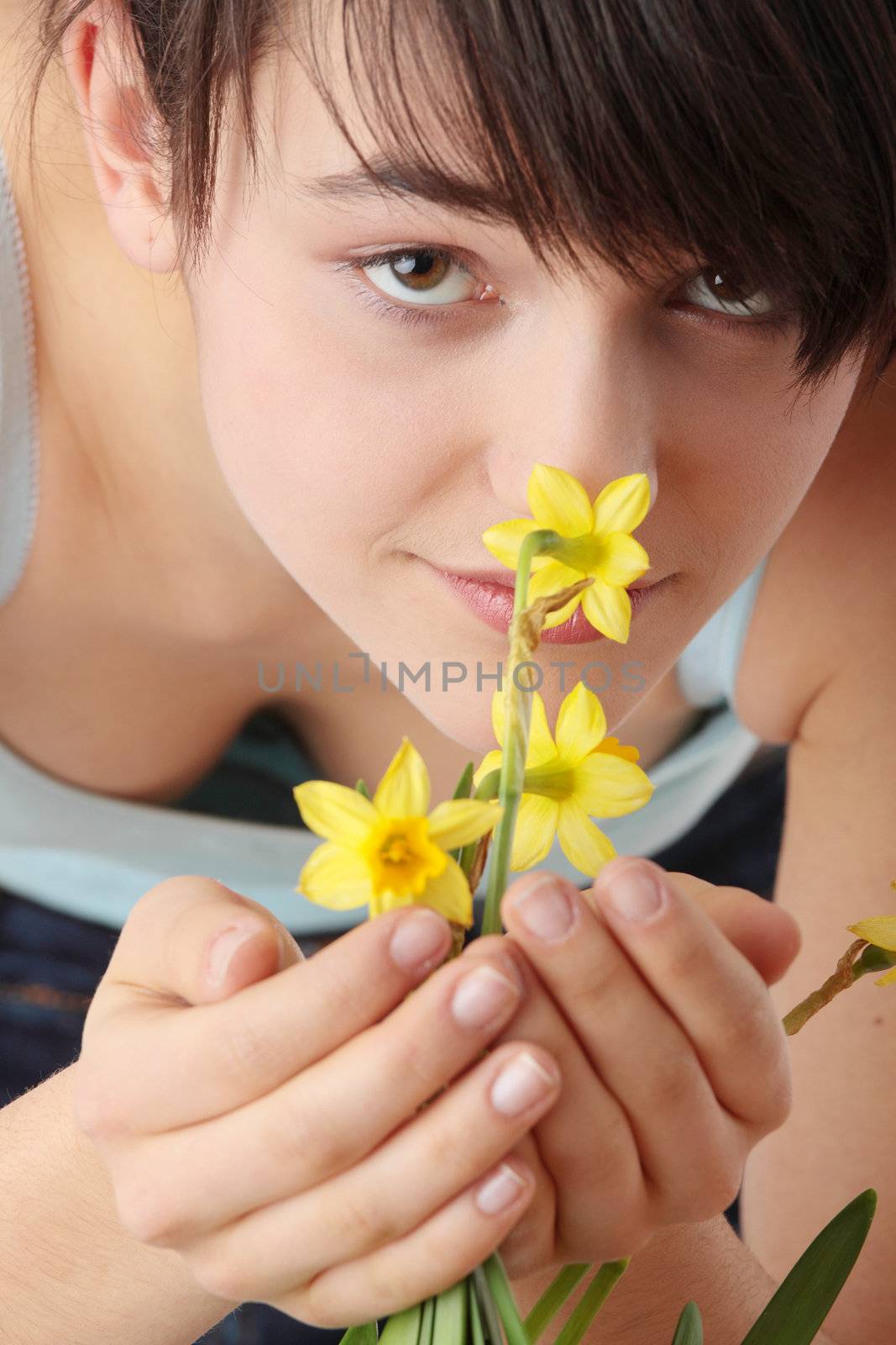 Teen girl smelling yellow spring flowers