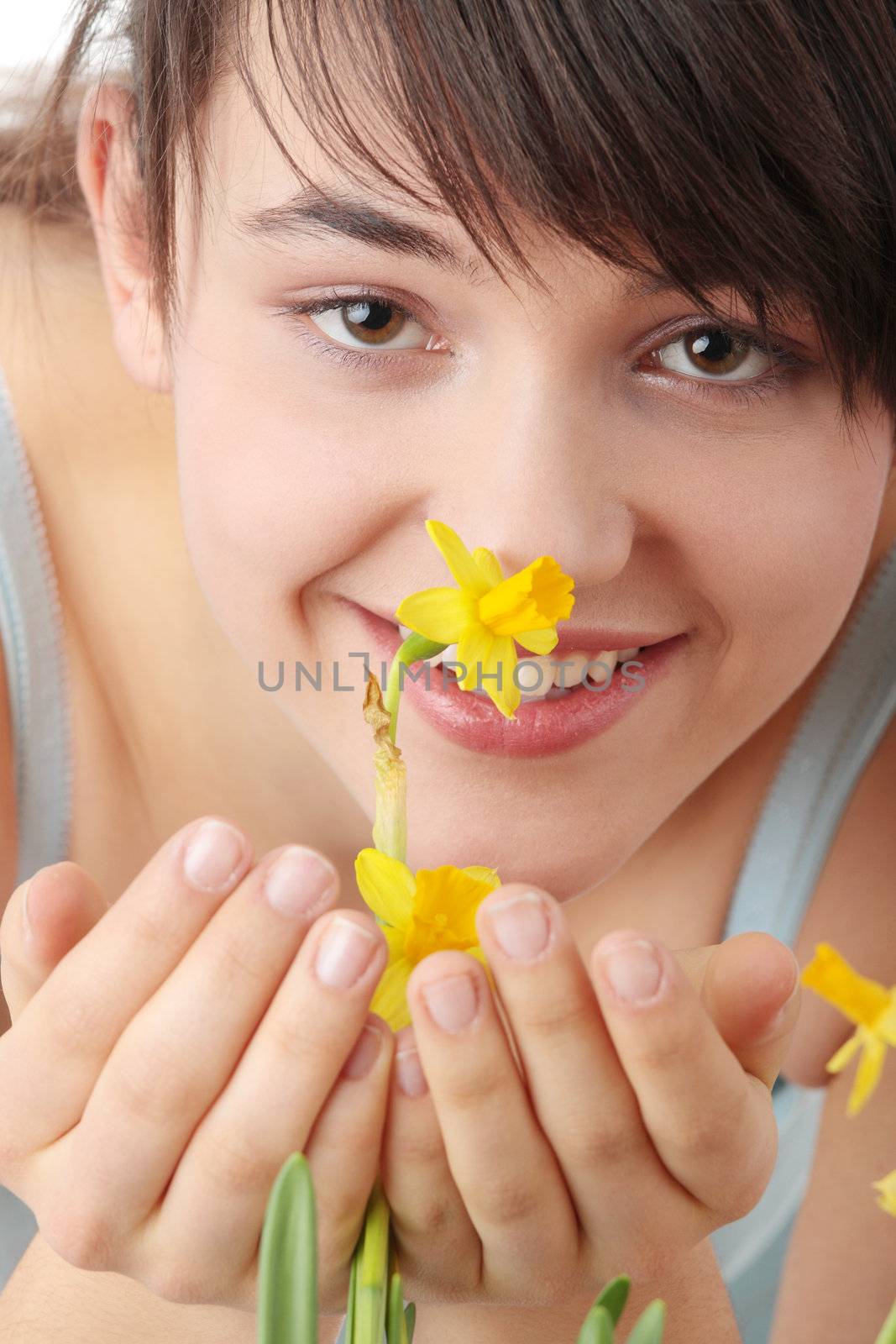 Teen girl smelling yellow spring flowers