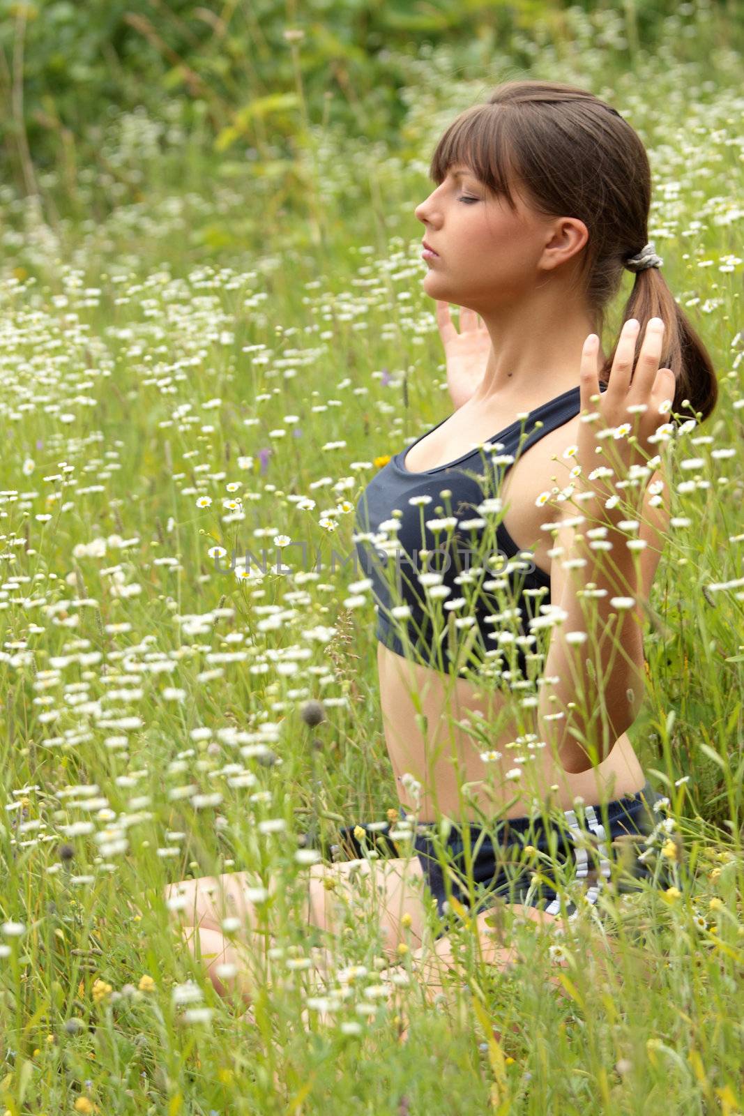 A young woman doing yoga outside in natural environment