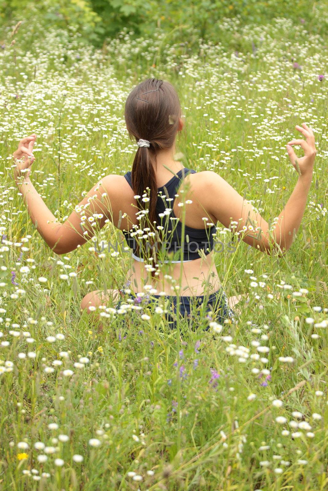 A young woman doing yoga outside in natural environment