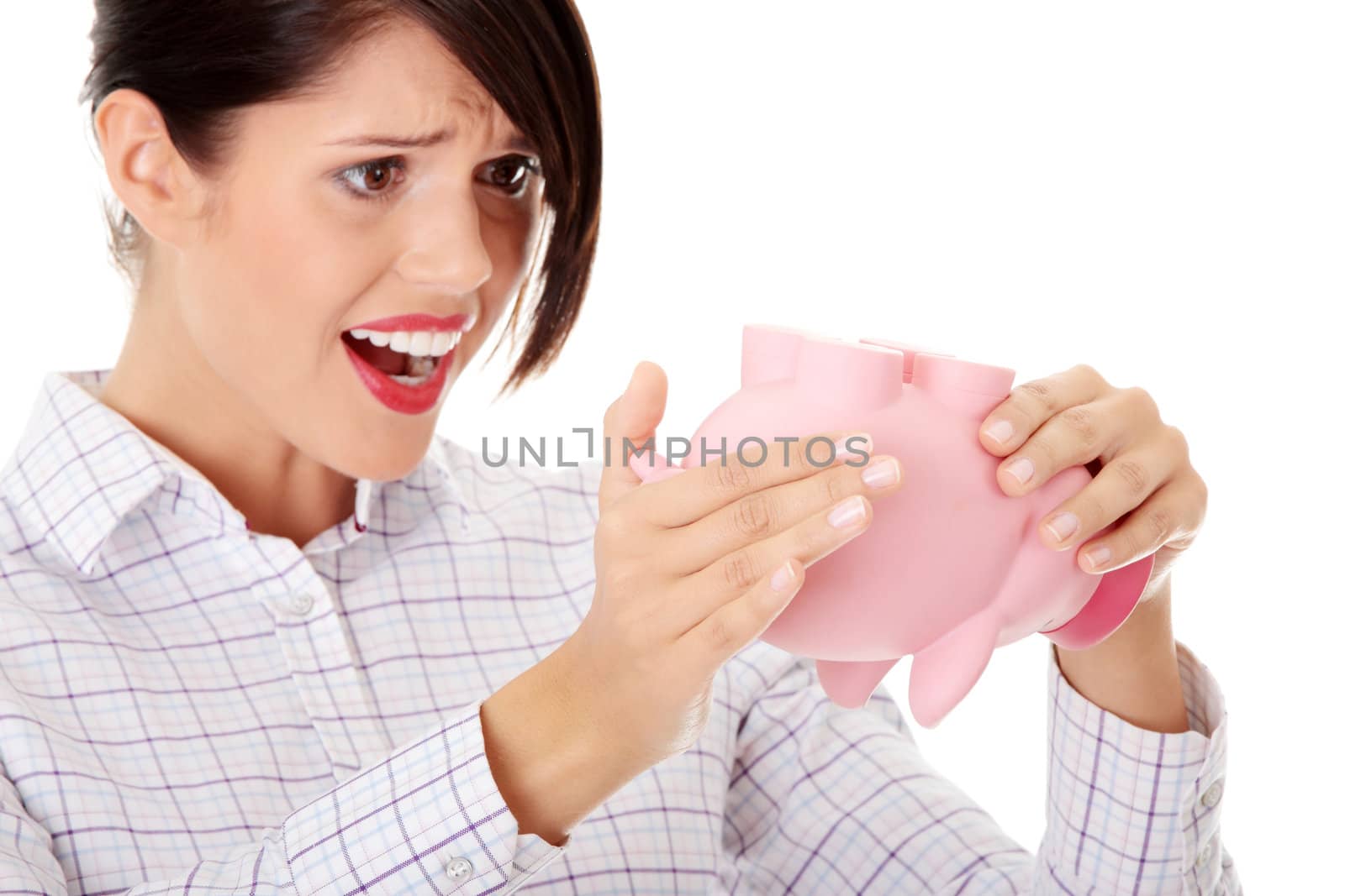 Young woman trying to get money from her piggy bank, isolated on white background