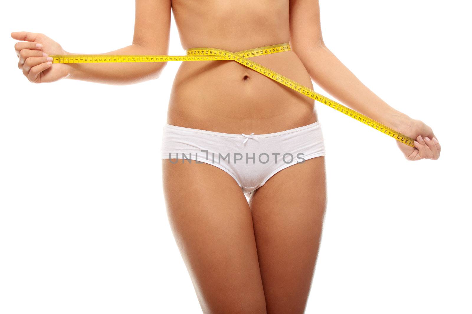 Naked belly of sexy, fit, young woman measuring her waist