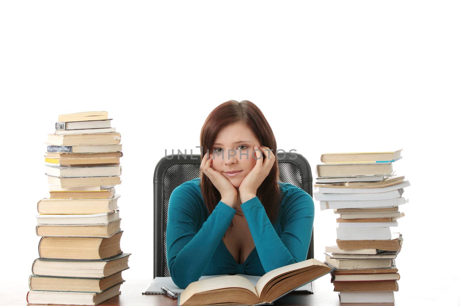 Teen girl learning at the desk with lot of books, isolated on white