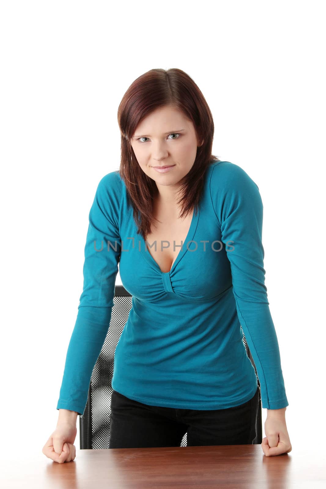 Young businesswoman leaning on desk, smiling.